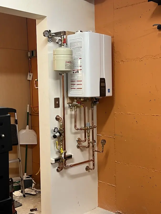 Plumbing technician inspecting water heater connections in Decatur